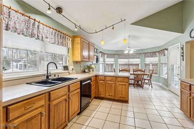 kitchen with black dishwasher, a peninsula, light countertops, a sink, and light tile patterned flooring