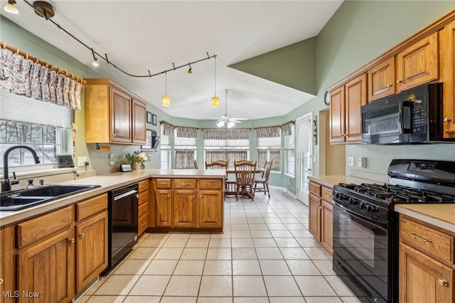 kitchen with light tile patterned flooring, a peninsula, a sink, light countertops, and black appliances