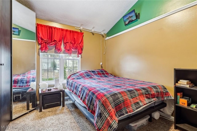 bedroom featuring carpet, vaulted ceiling, and a textured ceiling