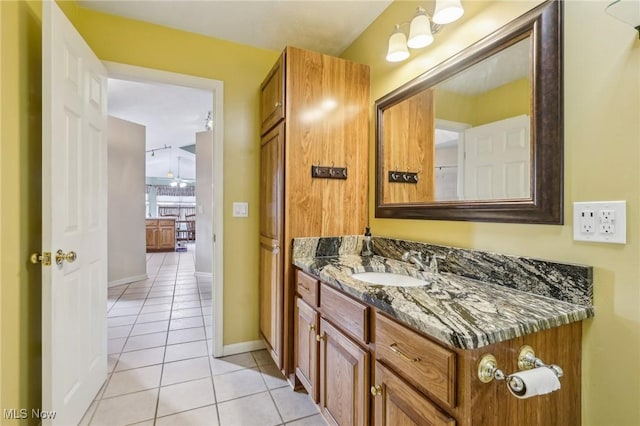 bathroom with vanity, baseboards, and tile patterned floors