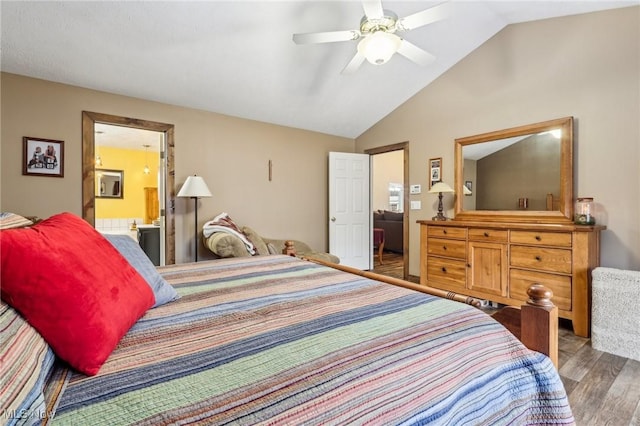 bedroom with a ceiling fan, vaulted ceiling, ensuite bath, and wood finished floors