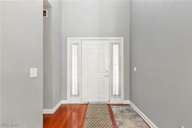 entrance foyer with baseboards and wood finished floors