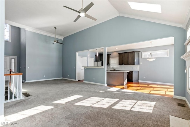 unfurnished living room with high vaulted ceiling, visible vents, and light colored carpet