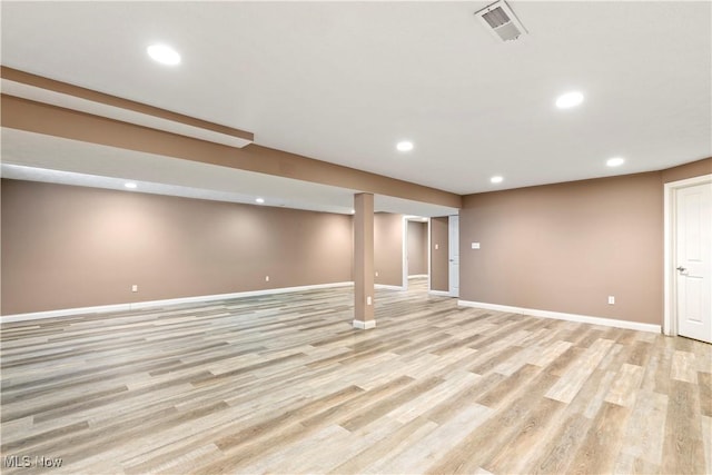 finished basement featuring baseboards, light wood-style floors, visible vents, and recessed lighting