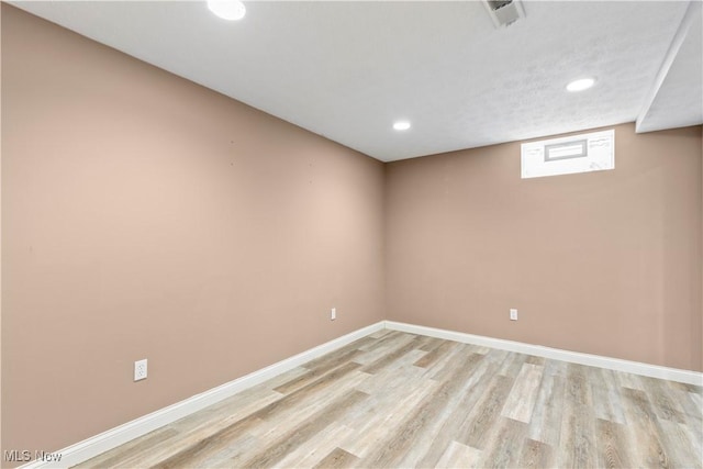 basement featuring light wood finished floors, visible vents, baseboards, and recessed lighting