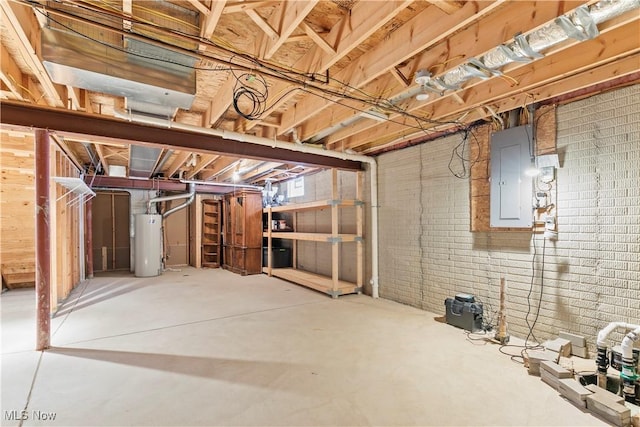 unfinished below grade area with electric panel, brick wall, and water heater