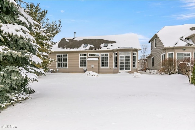 view of snow covered rear of property