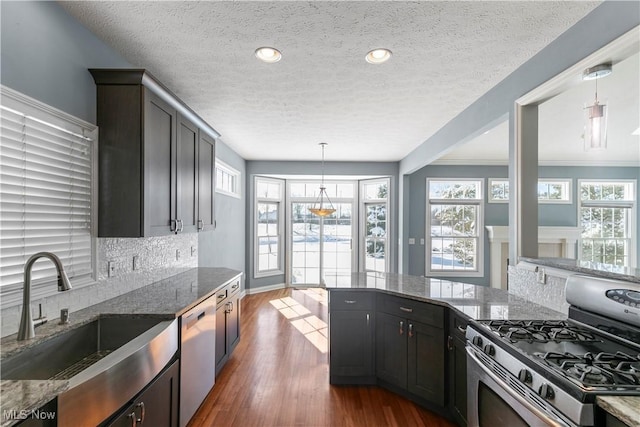 kitchen featuring a sink, dark wood-style floors, a wealth of natural light, dishwasher, and stainless steel range with gas stovetop