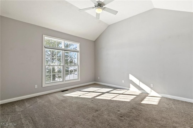 carpeted spare room featuring lofted ceiling, baseboards, visible vents, and ceiling fan