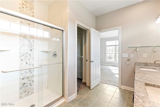 bathroom with a sink, a shower stall, and double vanity