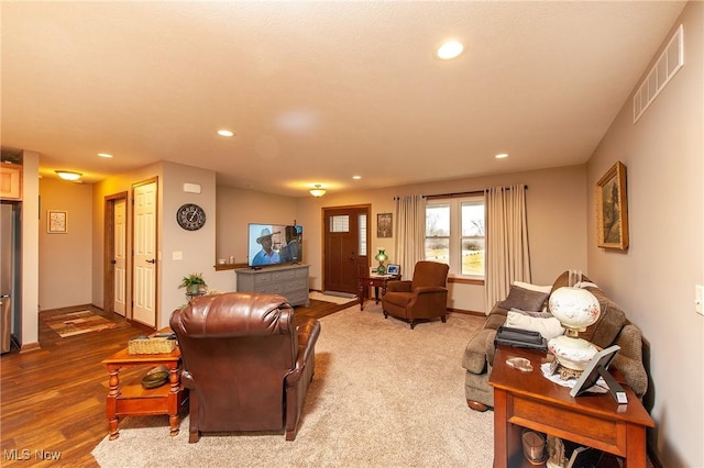 living room featuring baseboards, wood finished floors, visible vents, and recessed lighting