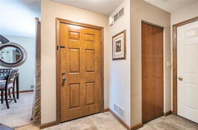 foyer entrance featuring visible vents and baseboards