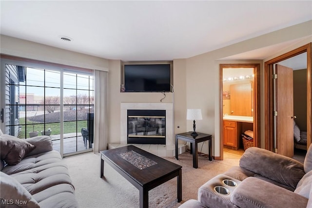 living room with light carpet and a glass covered fireplace