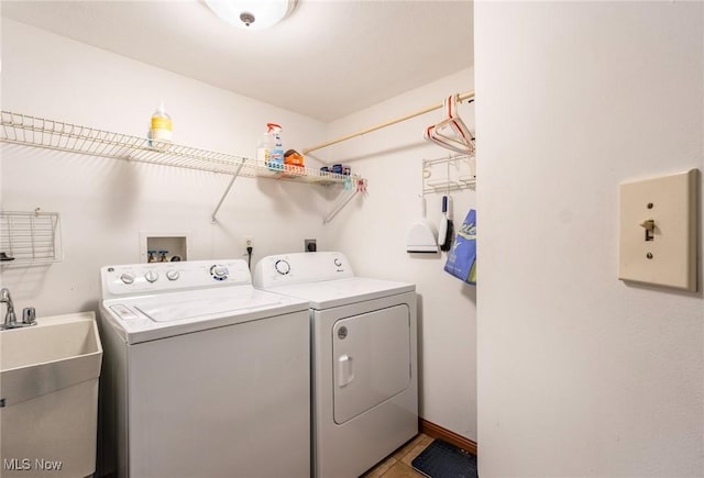clothes washing area with light tile patterned floors, laundry area, washer and clothes dryer, and a sink