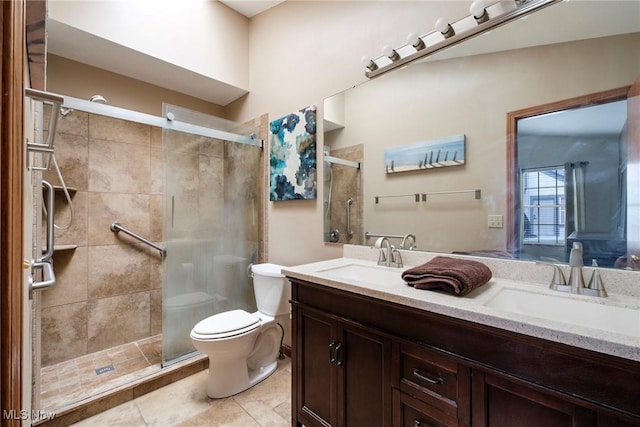 bathroom with toilet, a shower stall, double vanity, and a sink