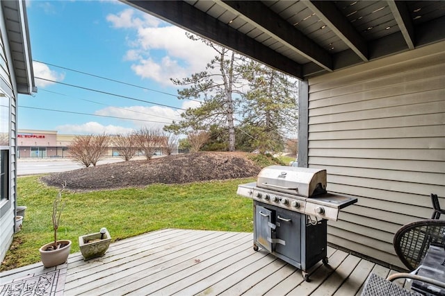 wooden terrace featuring a grill and a lawn