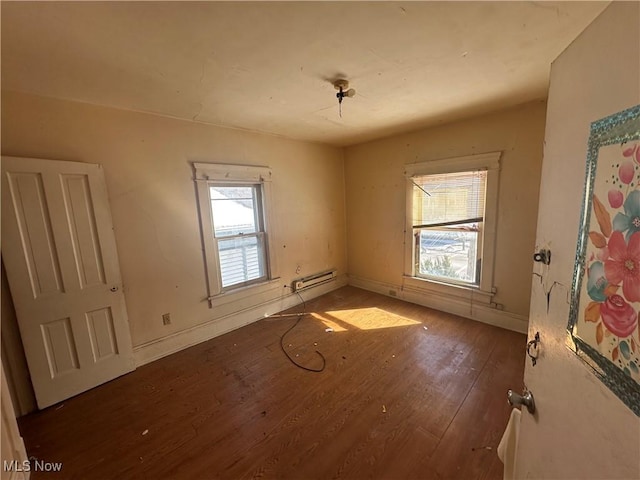 spare room featuring baseboards and wood finished floors