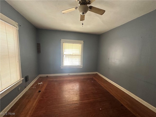 unfurnished room with ceiling fan, wood finished floors, and baseboards