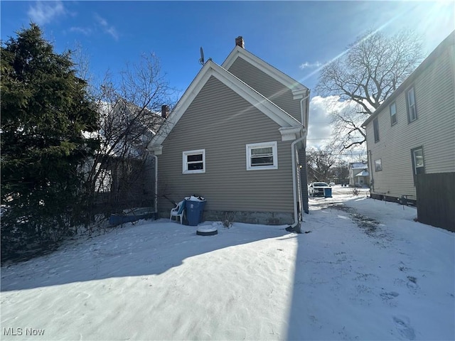 view of snowy exterior featuring a chimney