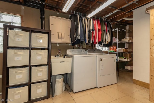 clothes washing area featuring light tile patterned floors and washer and clothes dryer