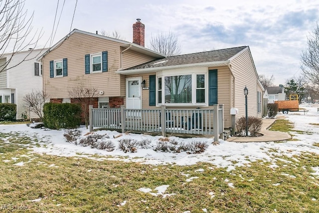 tri-level home with a porch and a chimney