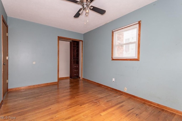 unfurnished bedroom with light wood-type flooring, a ceiling fan, baseboards, and a closet