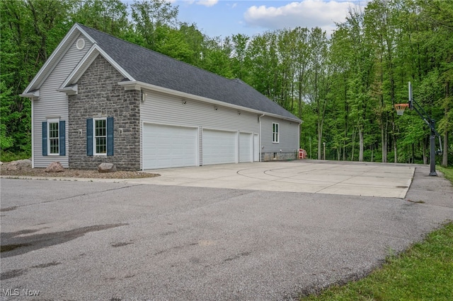 10565 Valley View Rd, Sagamore Hills, OH 44067 - view of property exterior featuring stone siding, driveway, and roof with shingles