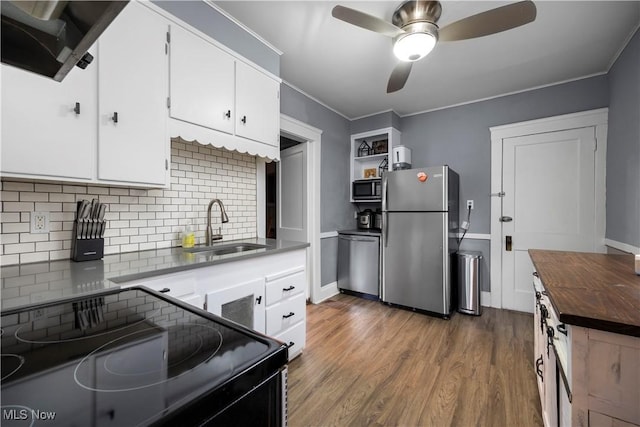 kitchen featuring white cabinets, wood counters, wood finished floors, stainless steel appliances, and a sink