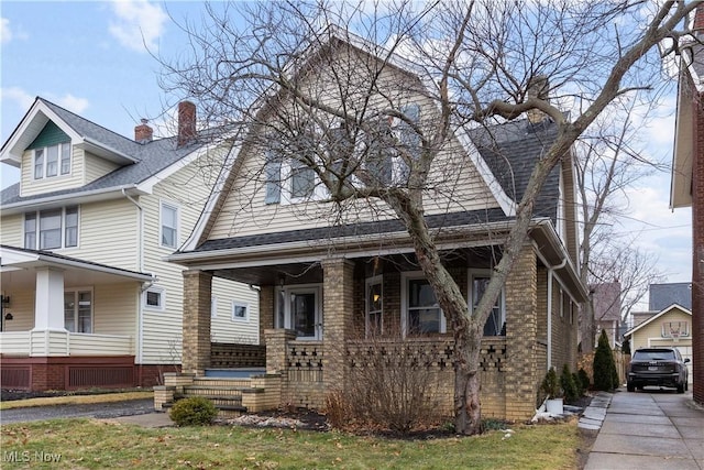 view of front of house with a porch and roof with shingles