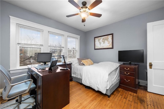 bedroom featuring a ceiling fan, baseboards, and wood finished floors