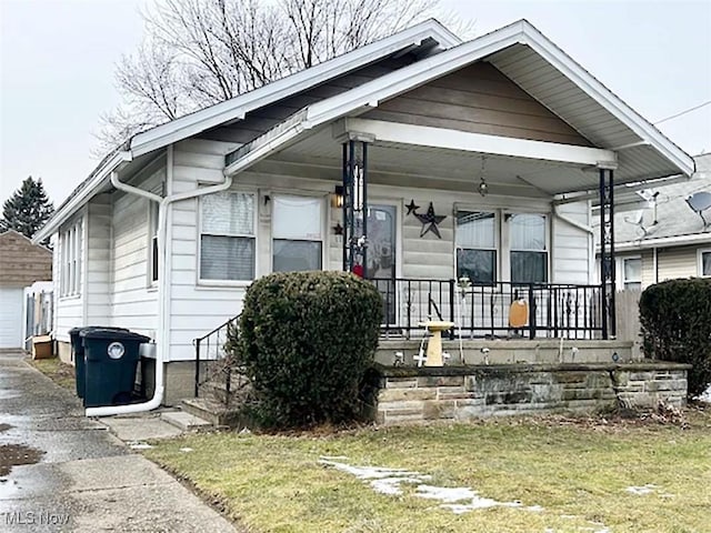 bungalow-style home with an outbuilding and covered porch