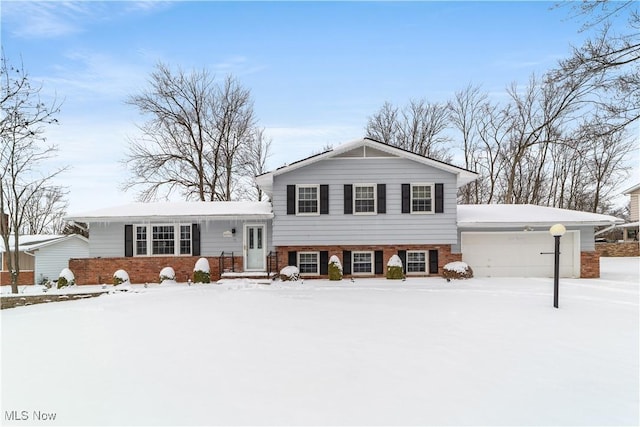 tri-level home with a garage and brick siding