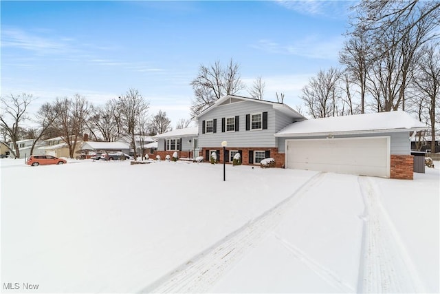 tri-level home featuring brick siding and an attached garage