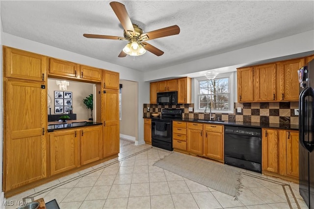 kitchen featuring dark countertops, black appliances, backsplash, and a sink