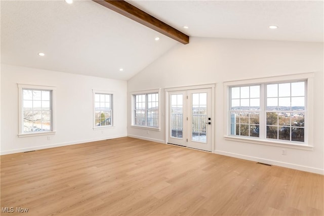 unfurnished living room featuring lofted ceiling with beams, light wood finished floors, and baseboards