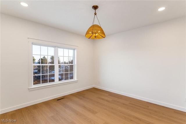 spare room with visible vents, light wood finished floors, and baseboards