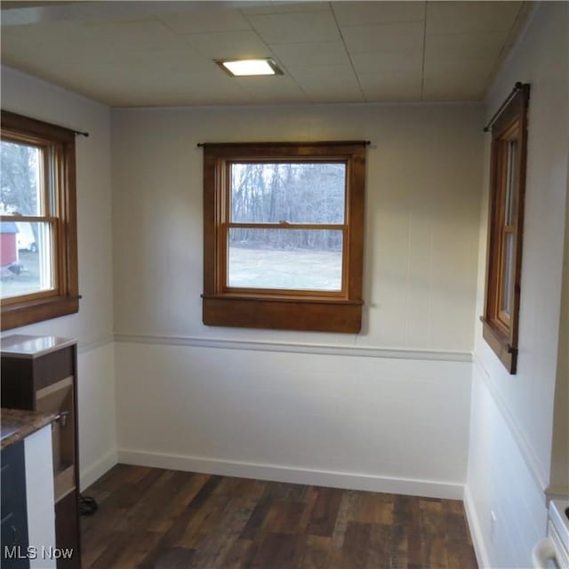 empty room featuring dark wood-type flooring and baseboards