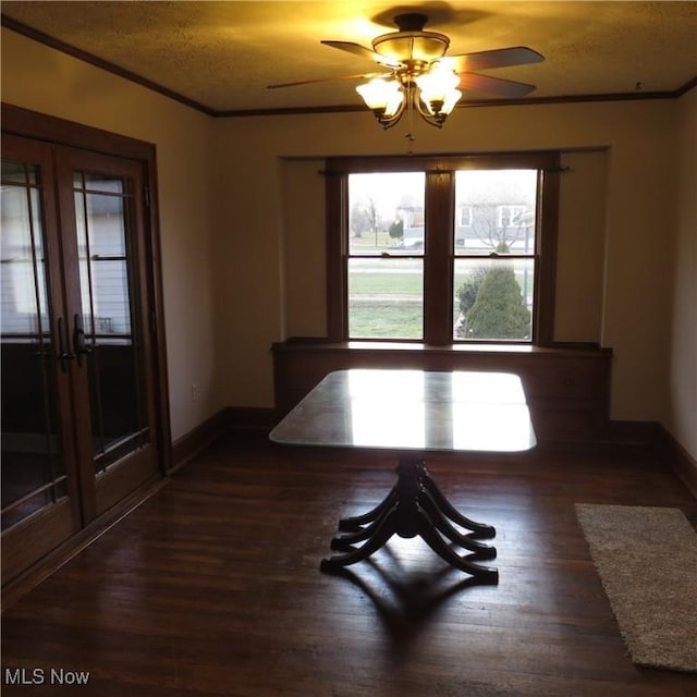 unfurnished dining area with french doors, crown molding, baseboards, and wood finished floors