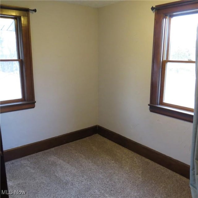 carpeted spare room with baseboards