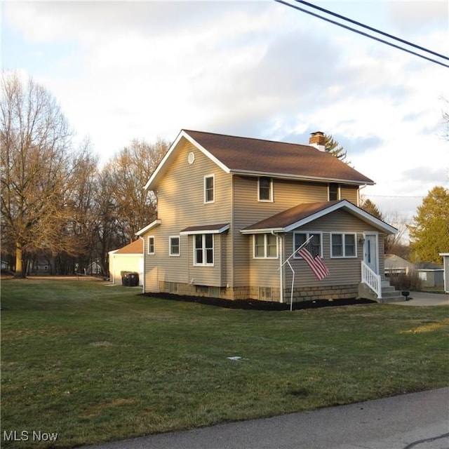 view of front facade with a front yard and a chimney