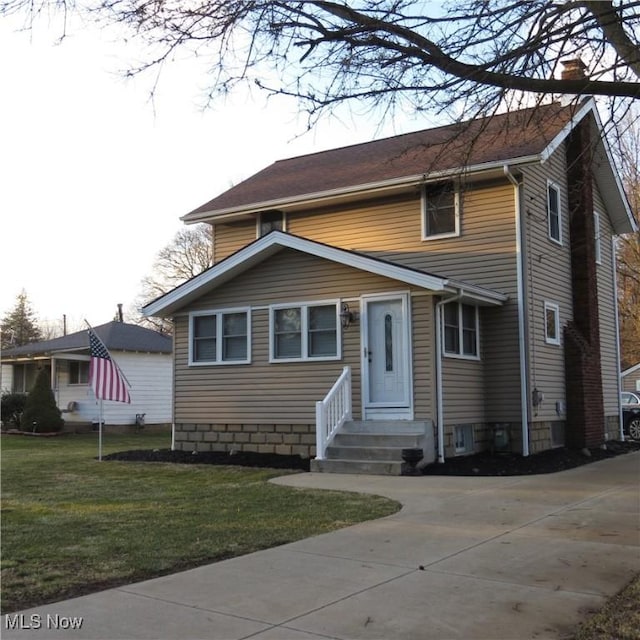 view of front facade featuring driveway, a chimney, and a front lawn