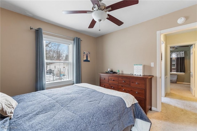 bedroom with light carpet, ceiling fan, and baseboards