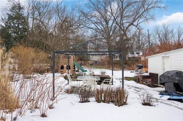 snowy yard featuring a playground