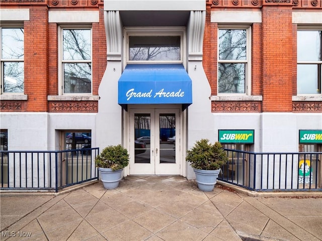 property entrance featuring french doors and brick siding