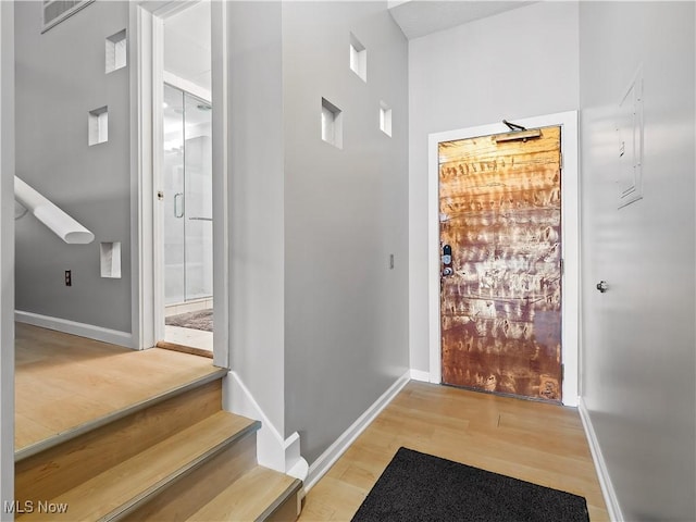 doorway to outside featuring visible vents, light wood-style flooring, and baseboards