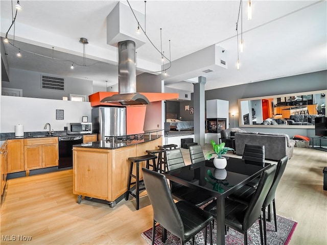 dining space with decorative columns, visible vents, and light wood-style floors