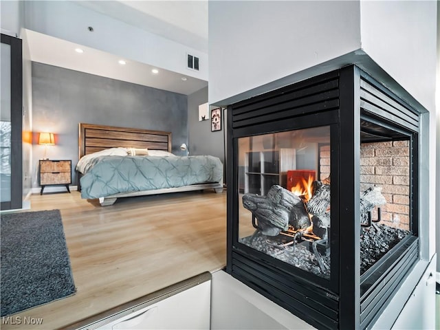 bedroom with visible vents, wood finished floors, and recessed lighting