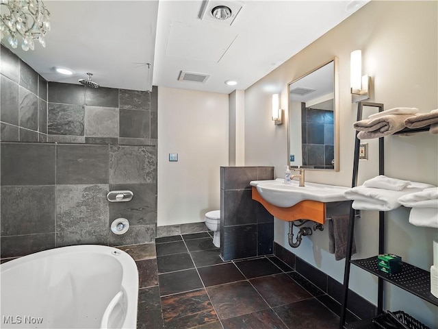 full bathroom with baseboards, visible vents, toilet, a soaking tub, and a walk in shower