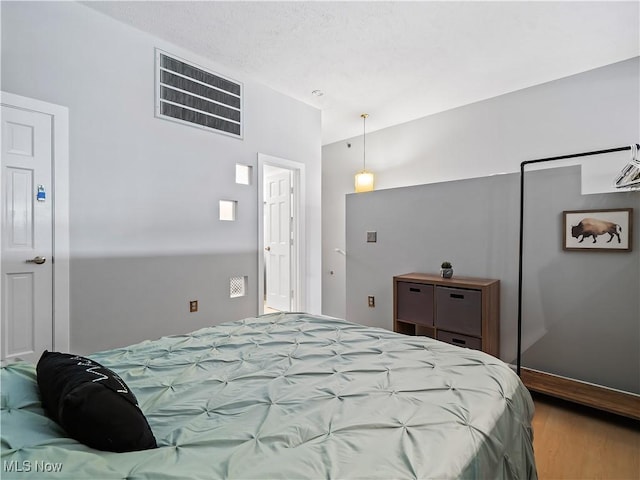 bedroom featuring visible vents and wood finished floors