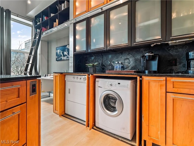 interior space with laundry area, separate washer and dryer, and light wood-style floors